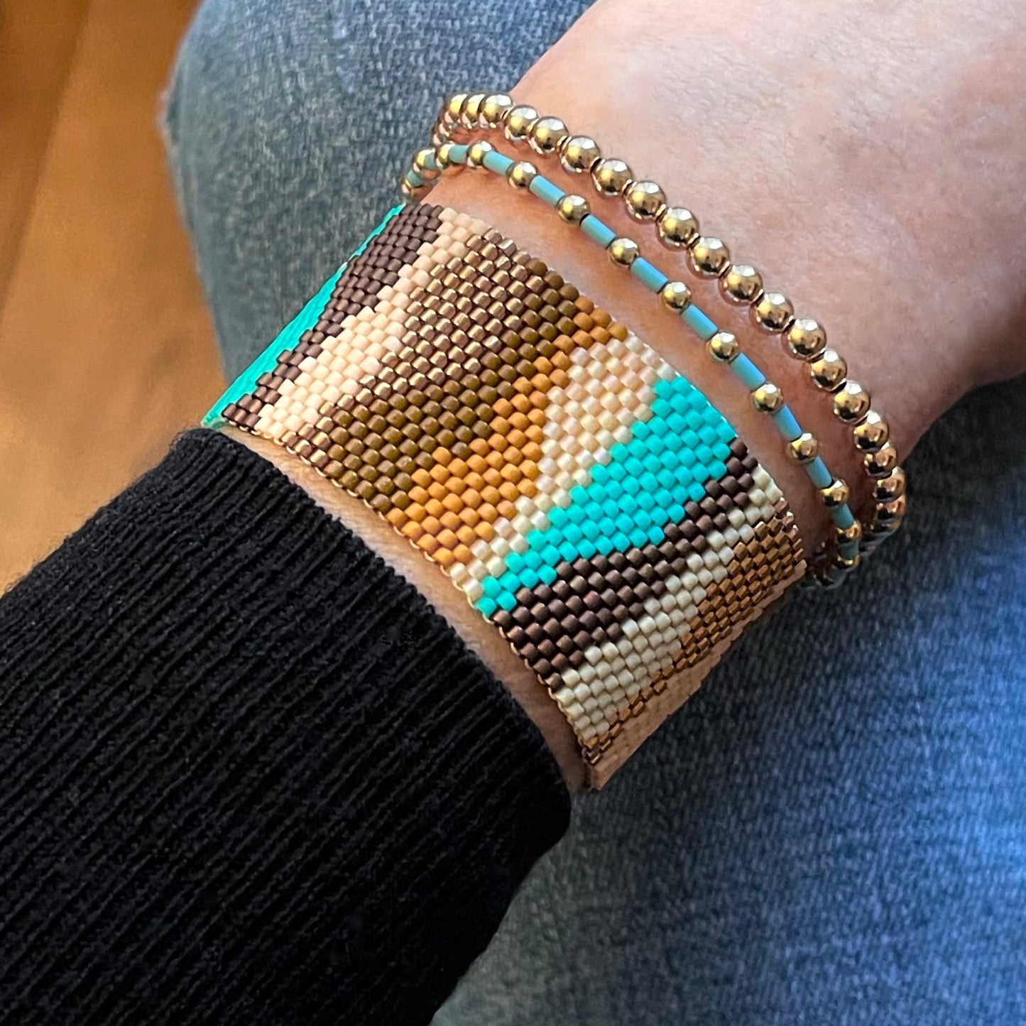 Camouflage blue and brown beaded bracelet in turquoise & tan, stacked with gold fill ball & seed bead stretch bracelets.