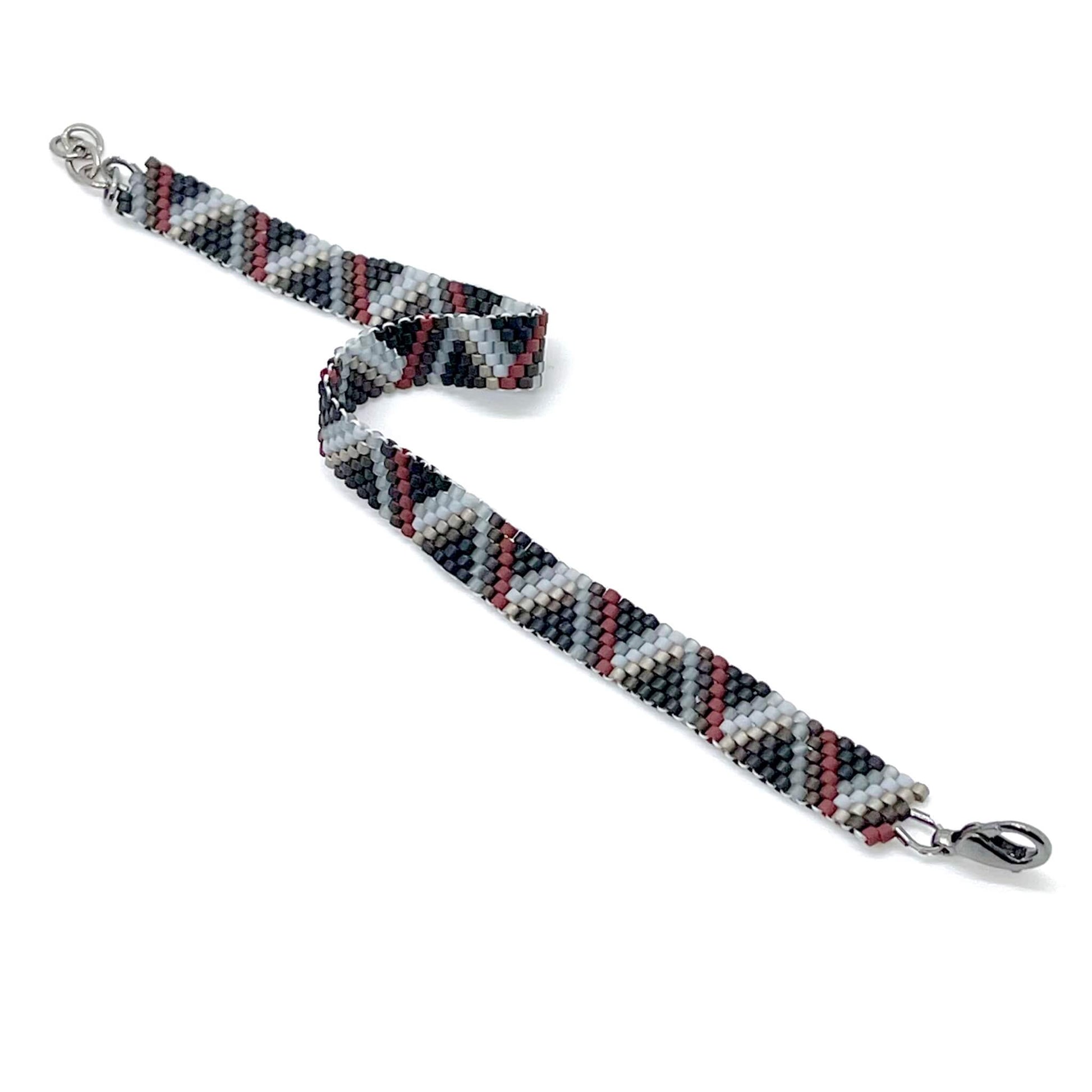 Hand woven men’s boho beaded peyote bracelet with clasp & black, white, gray, & dark red beads in striped triangles.