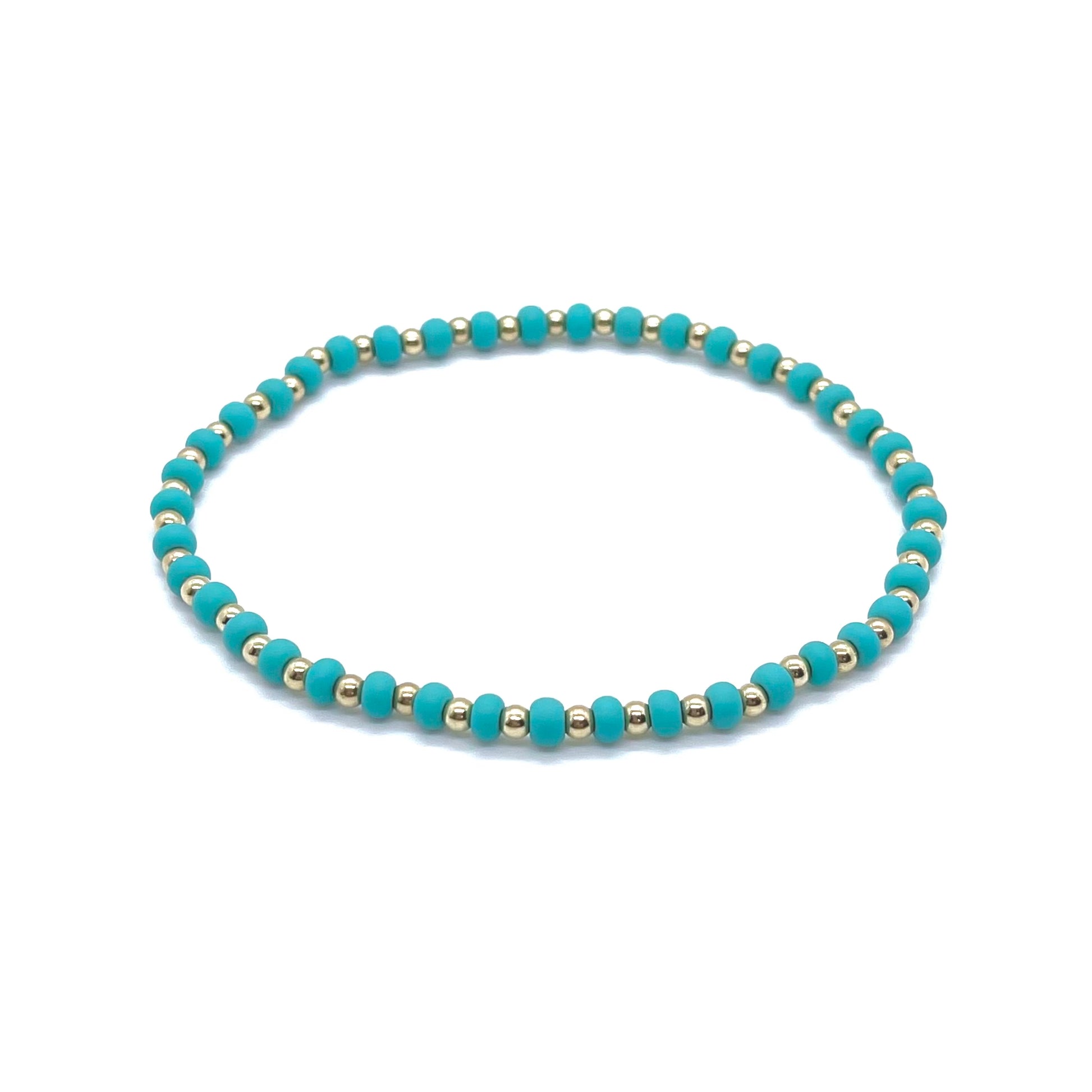 Gold ankle bracelet with 3mm waterproof gold-filled beads and matte aqua green seed beads on elastic stretch cord.