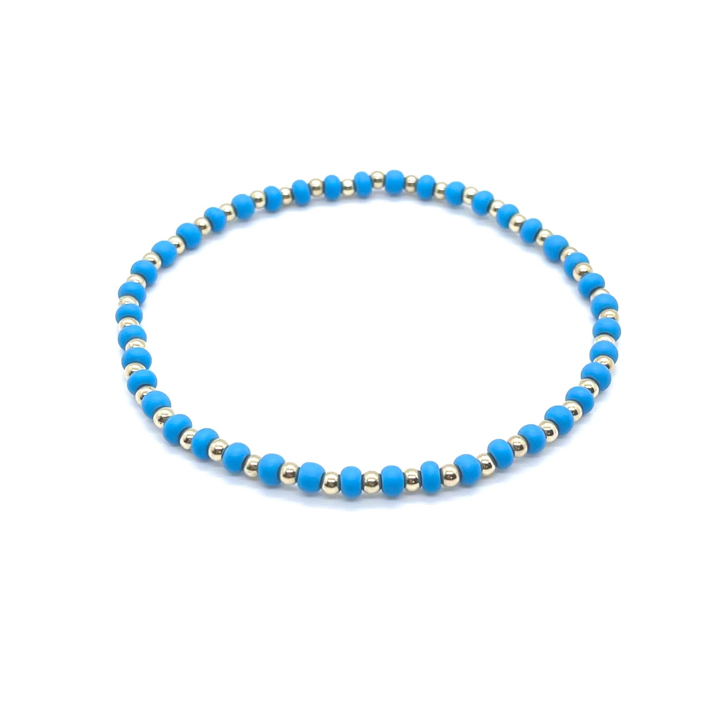 Gold fill anklet with alternating matte blue seed beads on elastic stretch cord. Handmade in NYC.