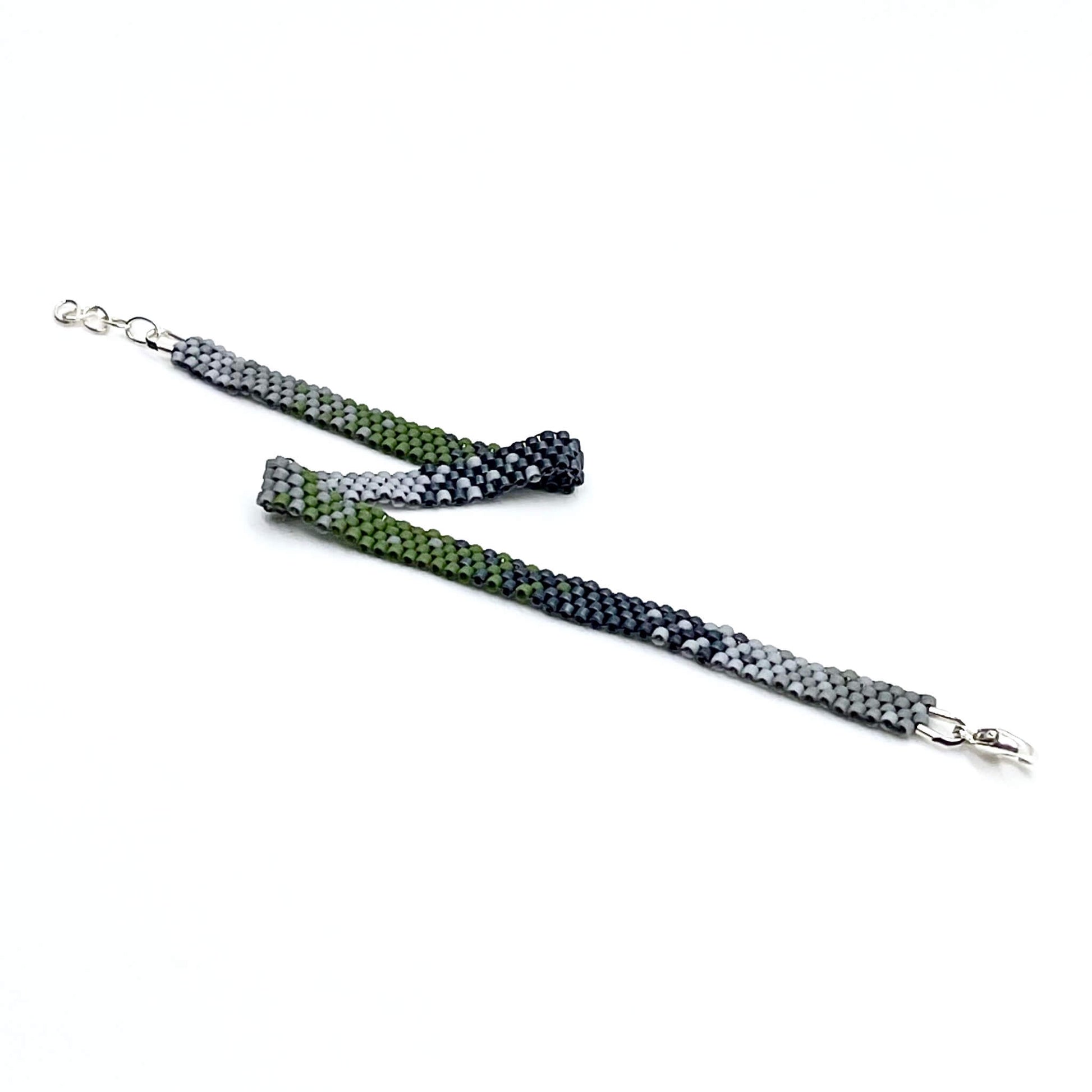 Hand woven men’s ombre style peyote beaded bracelet with sterling silver clasp and olive green, gray, & slate seed beads.