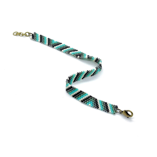 Stylish mens bracelet with black, white and aqua seed beads woven in stripes and triangles.
