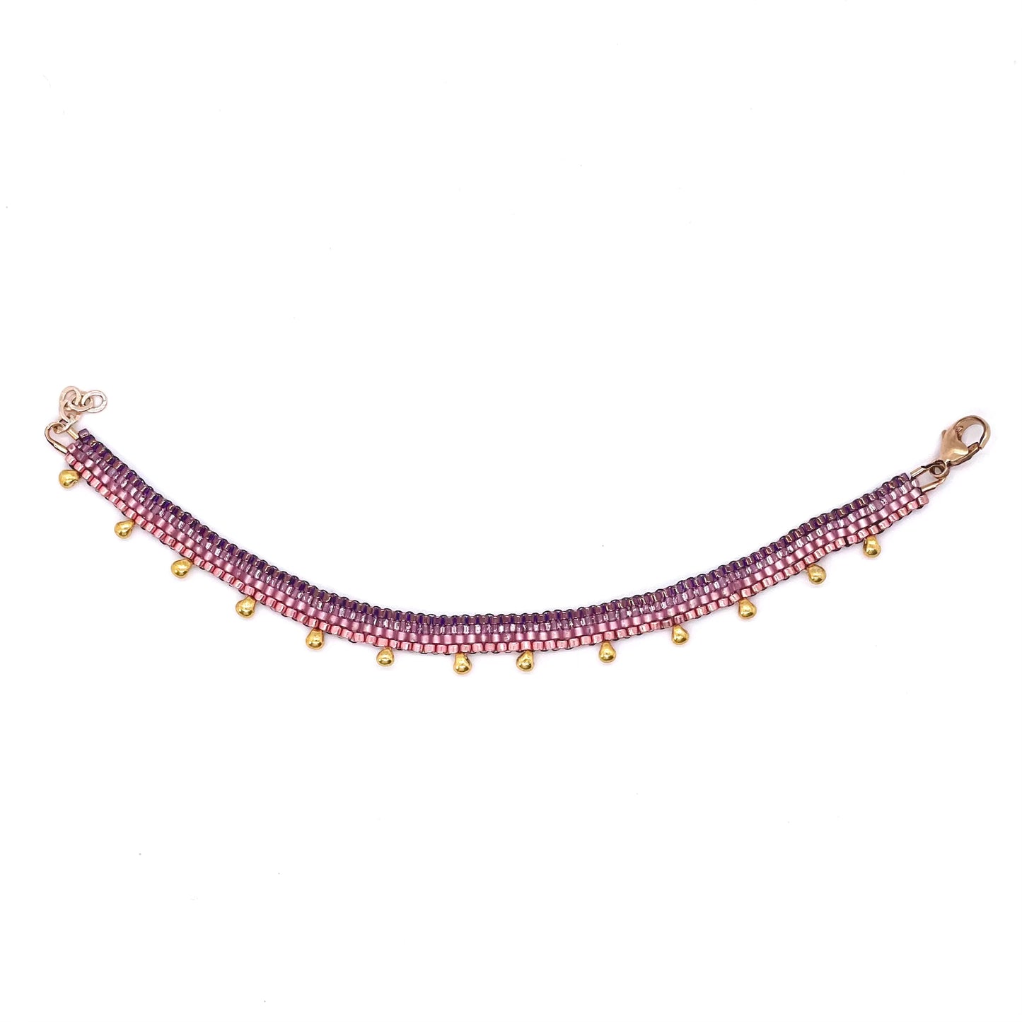 Pink beaded anklet handwoven using peyote stitch. Stripes in various shades of pink seed beads and gold-tone beaded drops.