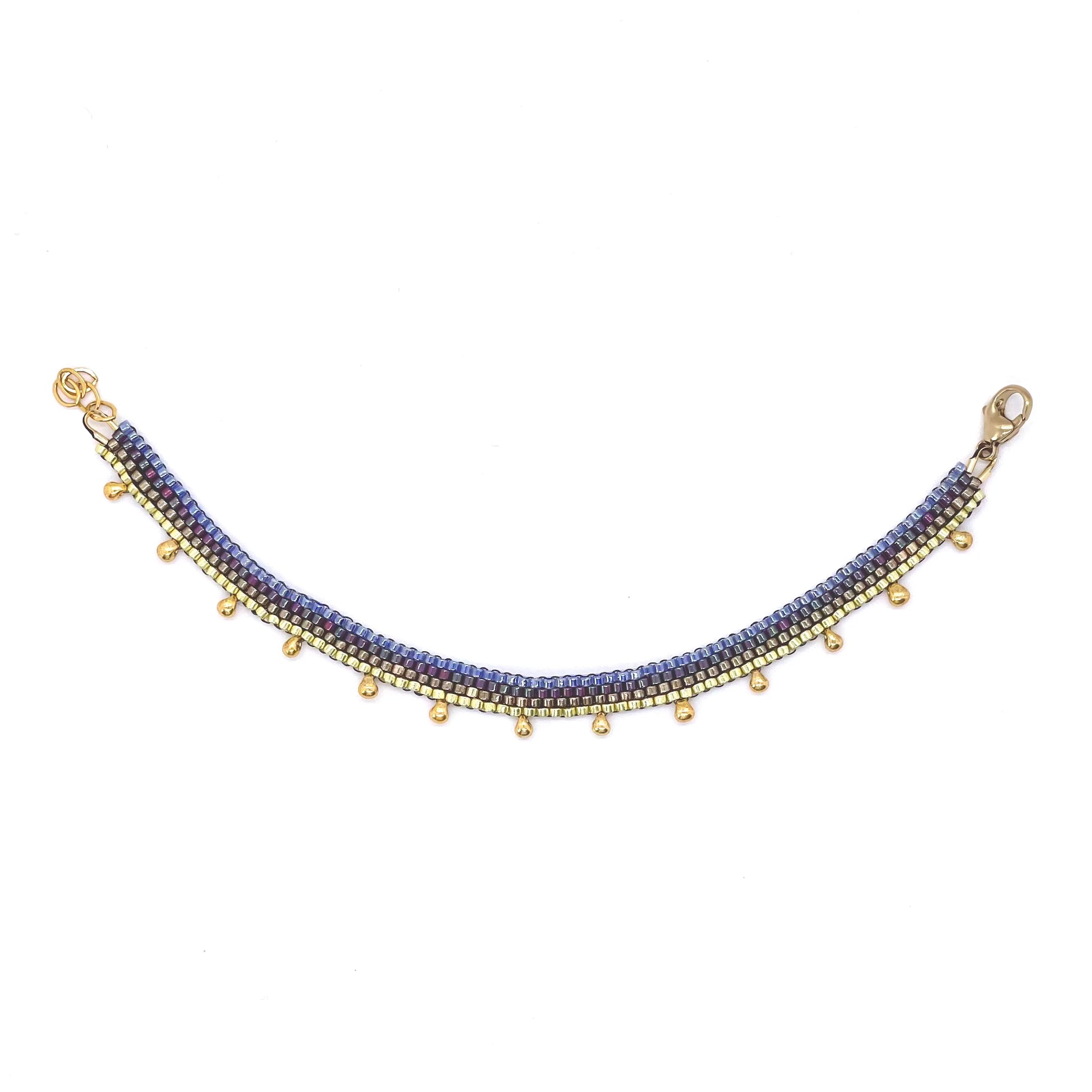 Thin anklet with gold tone and iridescent purple and blue seed beads. Colorful peyote stitch ankle bracelet.