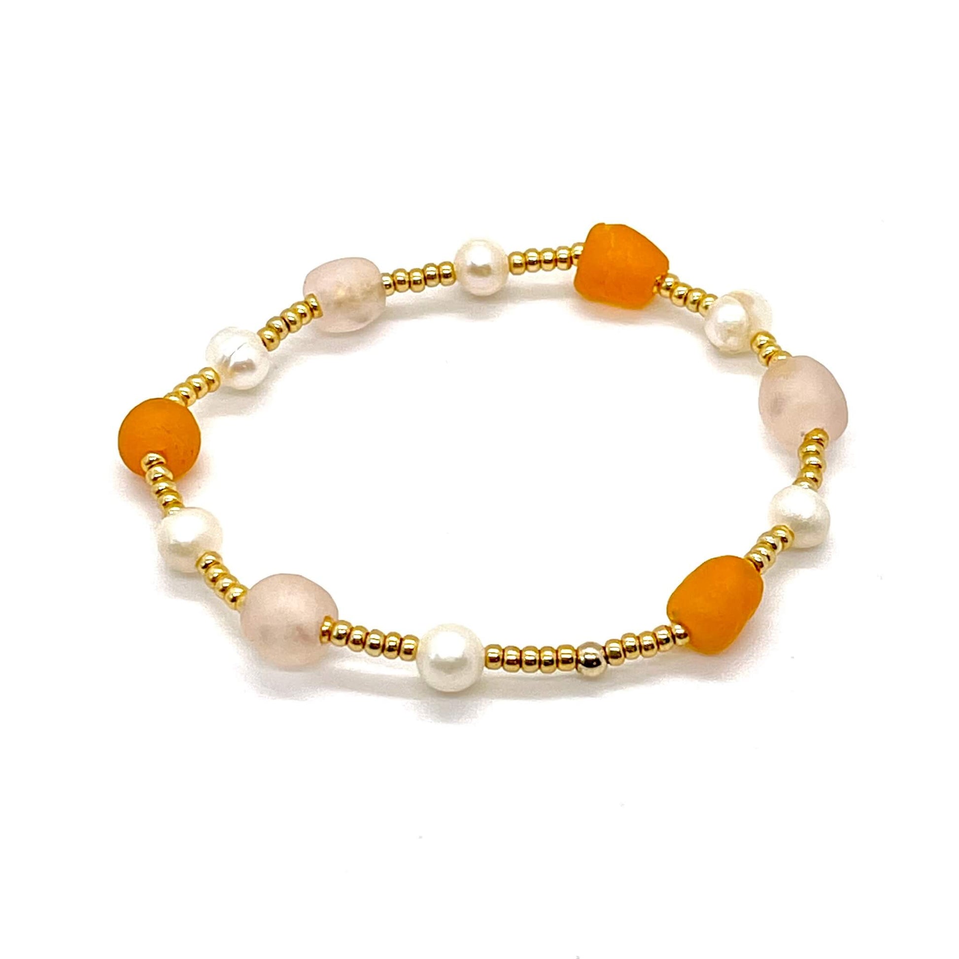Beach glass bracelet with peach and orange sea glass, round freshwater pearls, and gold tone seed beads.