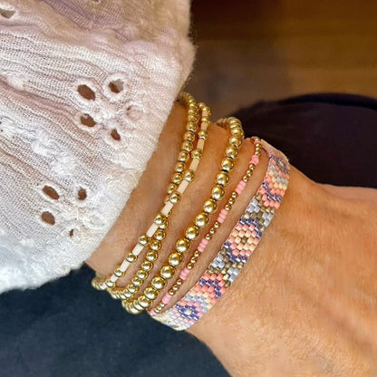 Bead bracelets for women featuring a woven seed bead bracelet and 4 gold ball stretch bracelets.