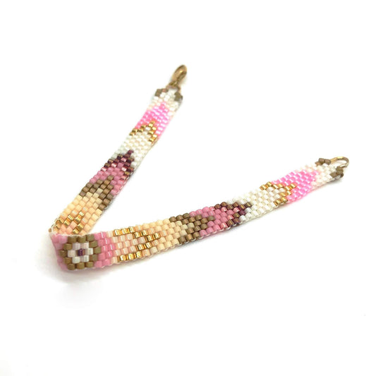 Thin beaded hand woven wristband with pink, rose, peach, cream, and gold glass seed beads in a peyote arrow pattern.