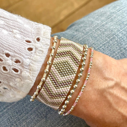 Beaded bracelet stack of 4 with woven and stretch bracelets in silver, mauve, and gray. Handmade with seed beads and sterling silver round beads.