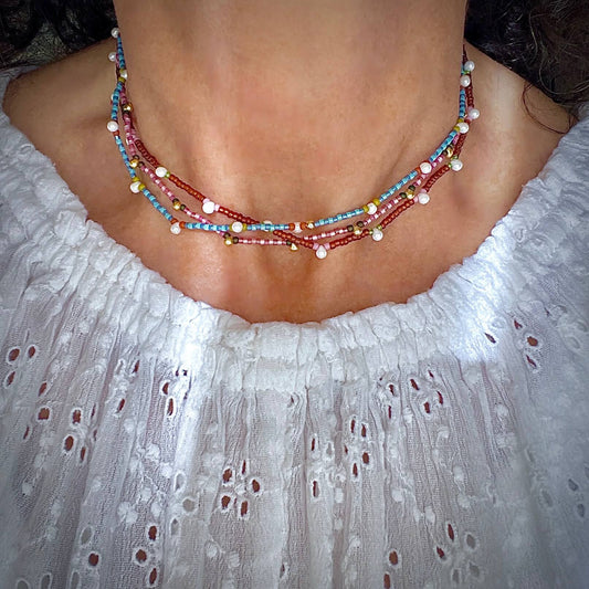 Beaded choker necklaces with blue, pink, and brown seed beads and pearl and gold-tone droplets. Stretchy for easy on and off.
