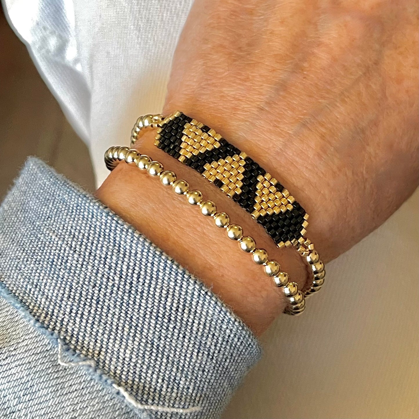 Black and gold triple heart band with 4mm 14K gold filled stretch bracelet. Tarnish resistant and waterproof. Made in NYC.