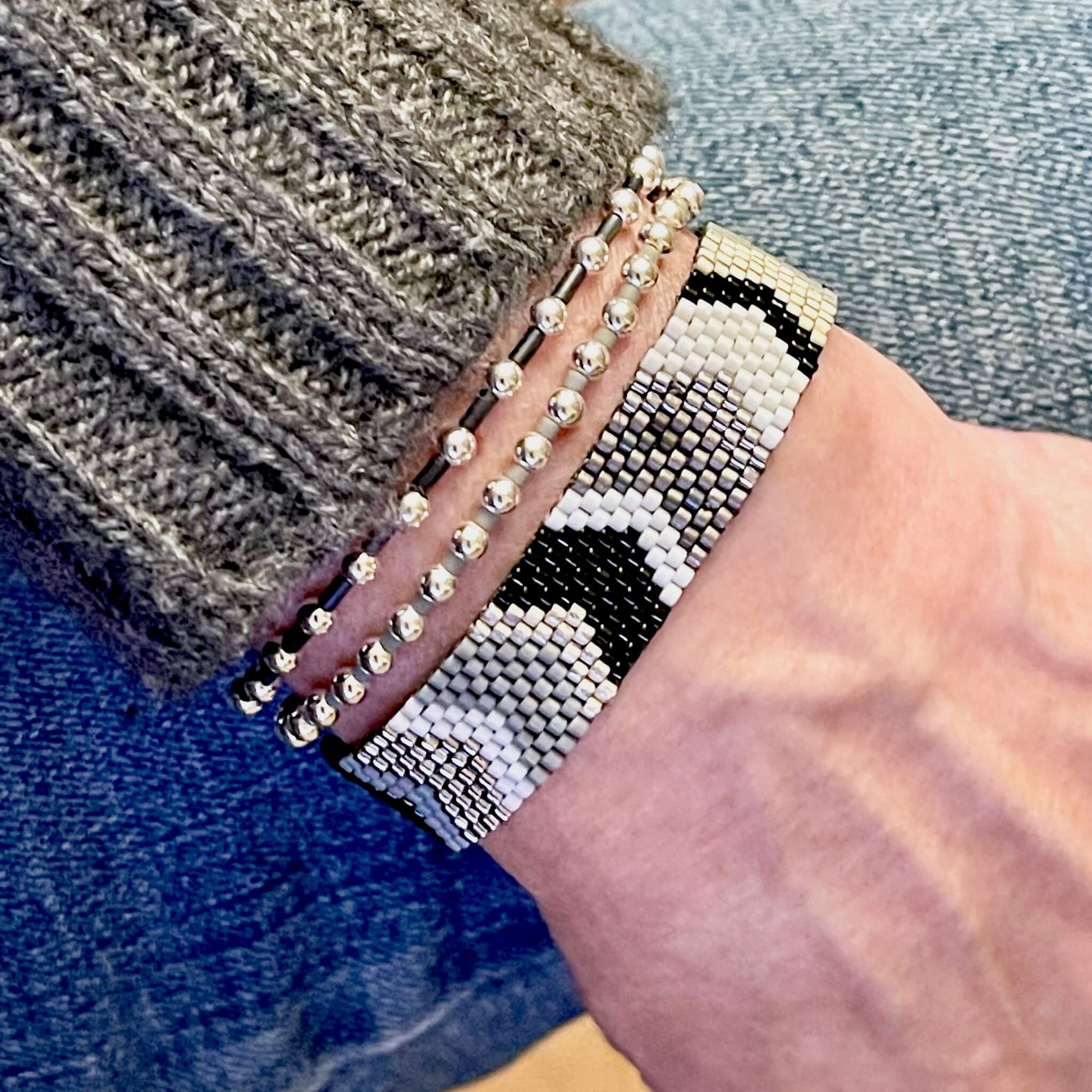 Black, white, and silver chevron beaded bracelet stack with a woven band and 2 coordinating stretch bracelets.