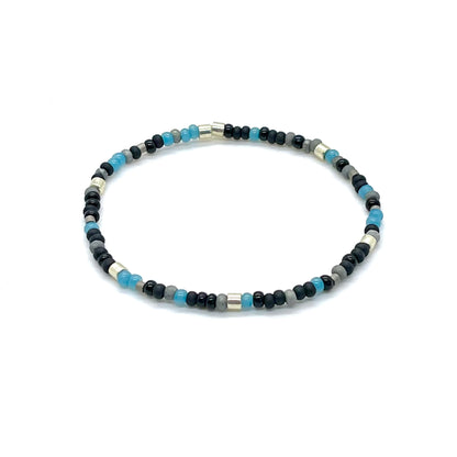 Blue bead bracelet for men with a mix of blue, gray, black and silver tone matte and glossy glass seed beads on elastic stretch cord.