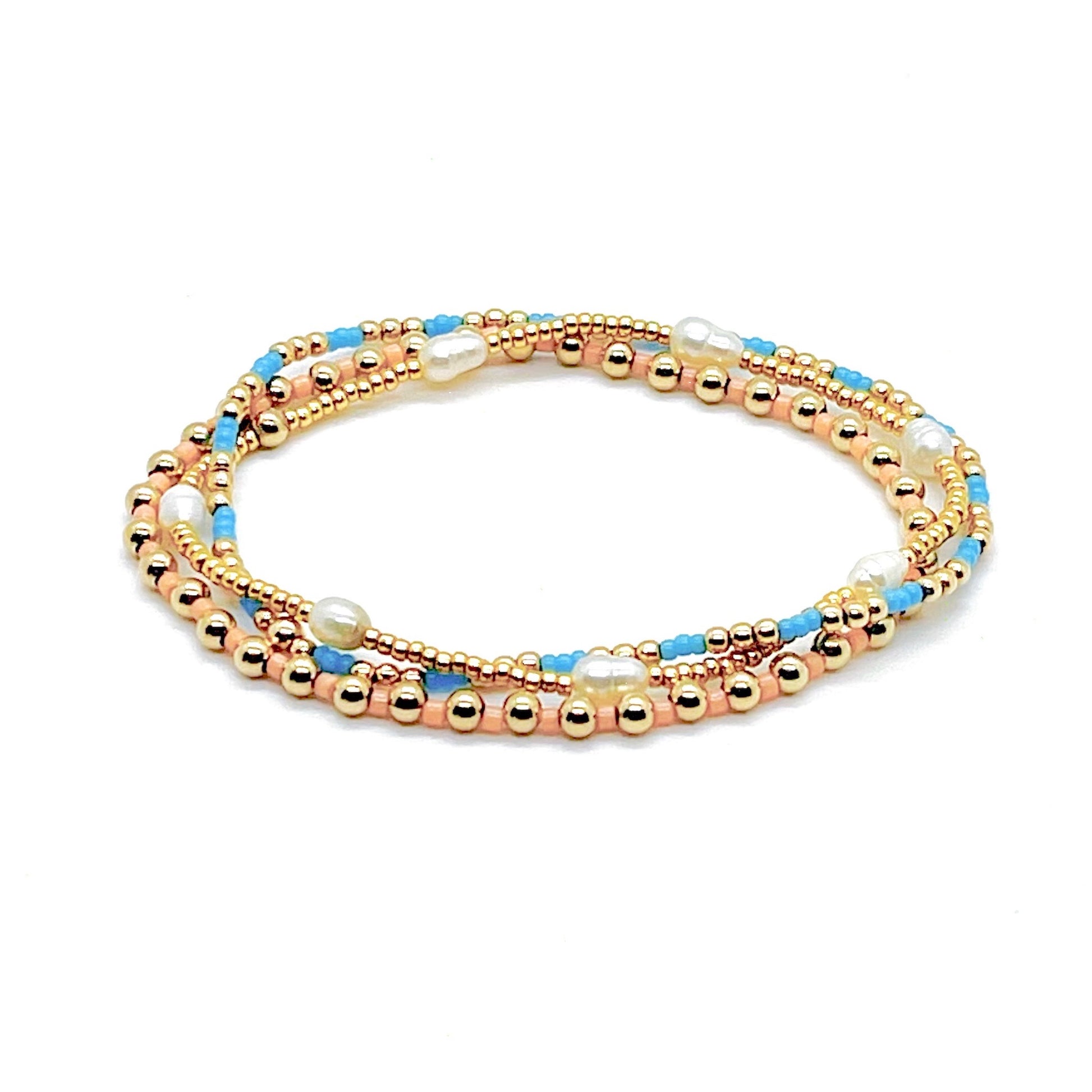 Blue, peach, and freshwater pearl gold bracelet stack of 3 stretch bracelets.