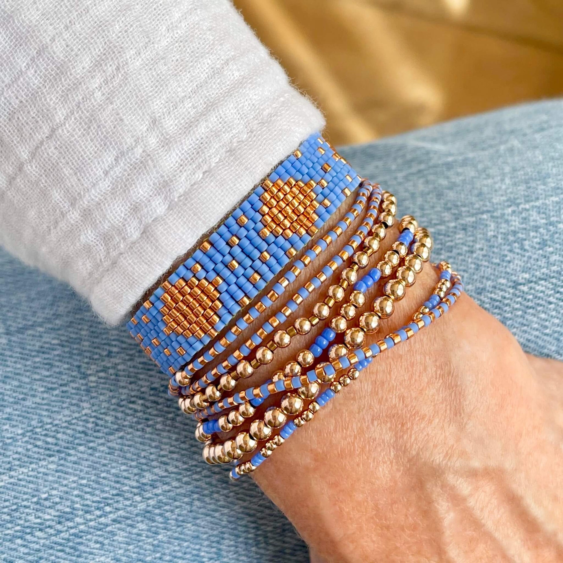 Bracelet stack featuring small blue glass seed beads, and 14K rose gold filled  round beads.