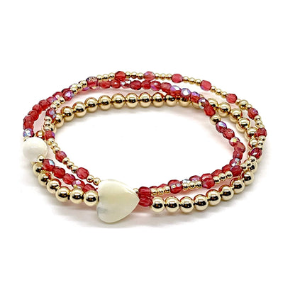 Bridesmaid bracelet gift. Coral red crystals, 14K gold filled beads, and mother-of-pearl round and heart shaped accent beads.