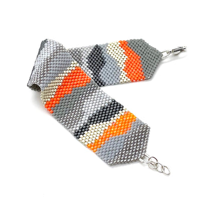 Camo bracelet with gray, silver, and orange beads.