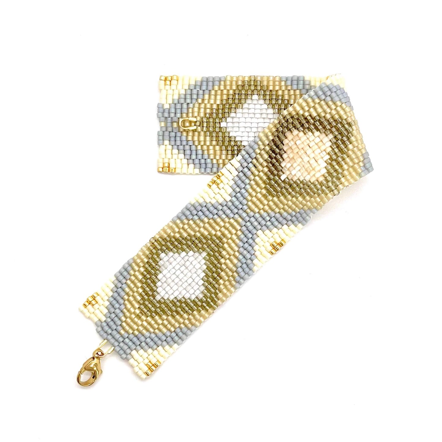 Stylish modern neutral tone wide woven beaded cuff bracelet in summer shades of cream, gold, beige, tan and gray.