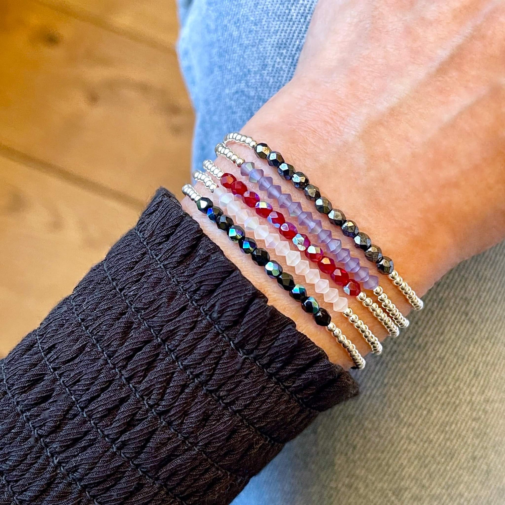 Dainty silver stretch bracelets with tiny crystal beads arranged in a center color bar. Choice of blue, white, red, lavender, or black crystals.