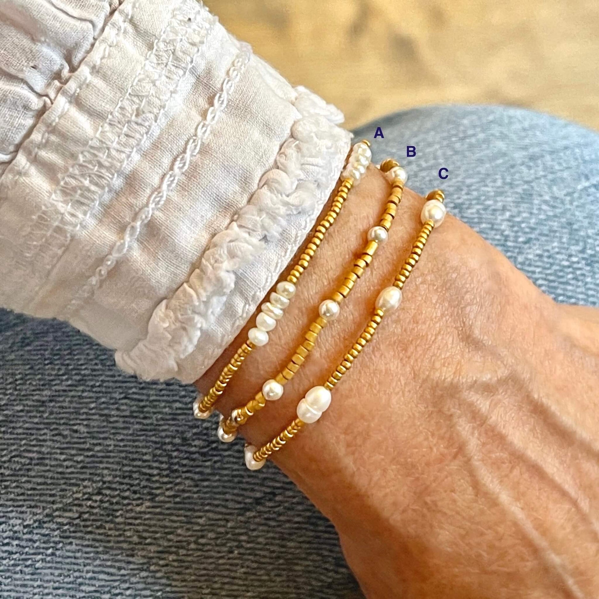 Dainty pearl bracelets with matte gold-tone seed beads and assorted white freshwater and crystal pearls on stretch cord.