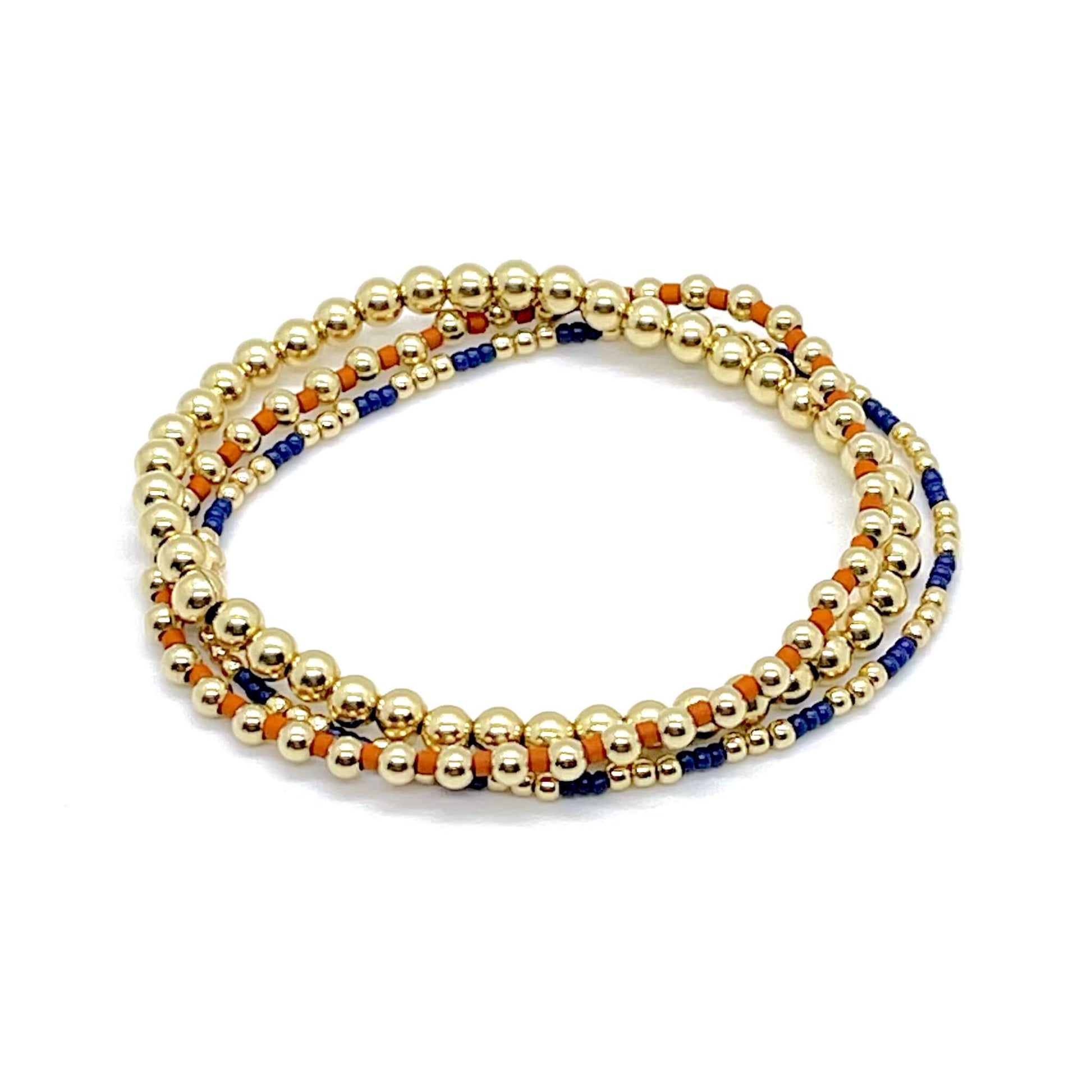 Set of 3 delicate beaded stretch bracelets with tiny navy and burnt orange glass seed beads and 14k gold-fill beads.