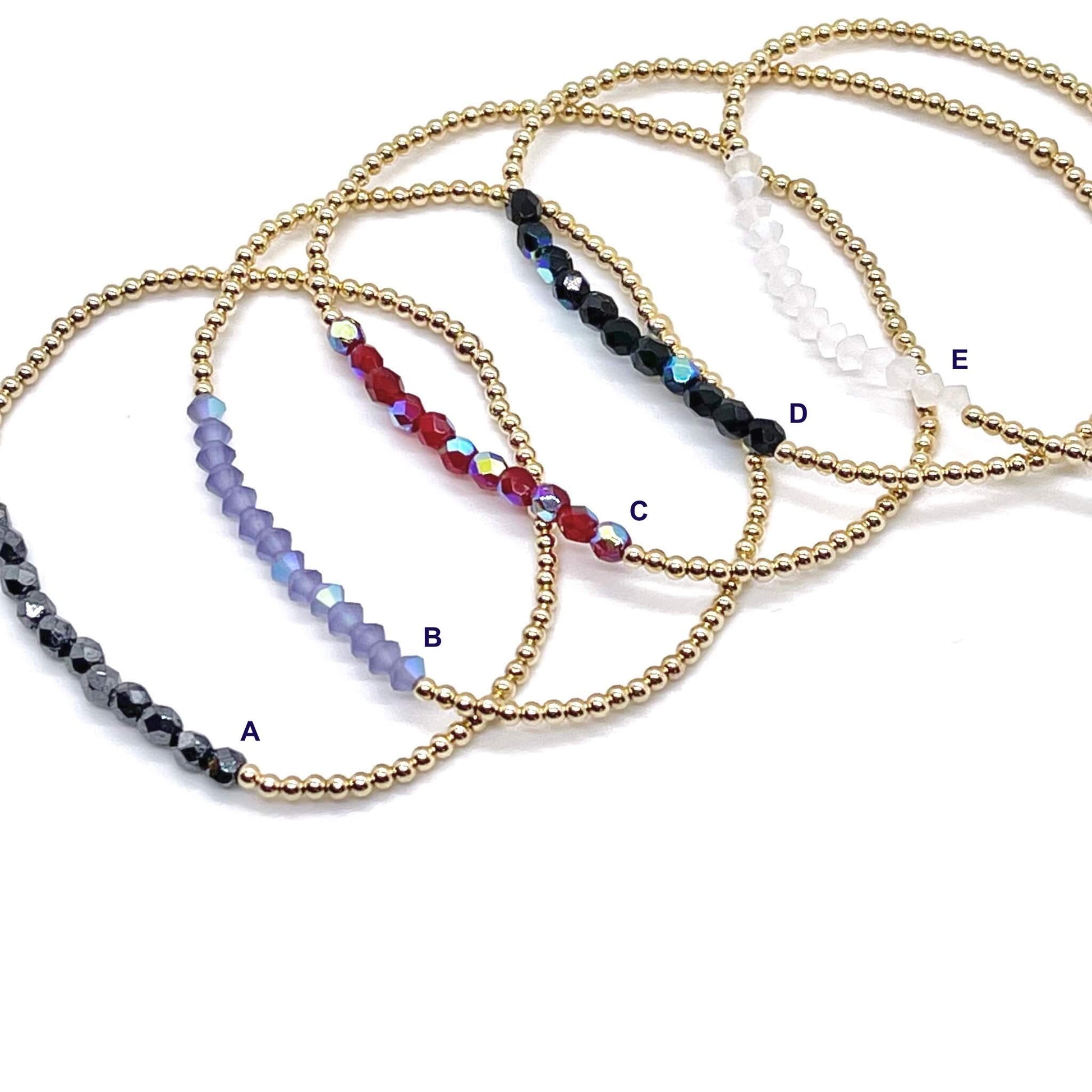 Skinny gold beaded bracelets with crystal color bars in a choice of hematite, lavender, red, black, or white.