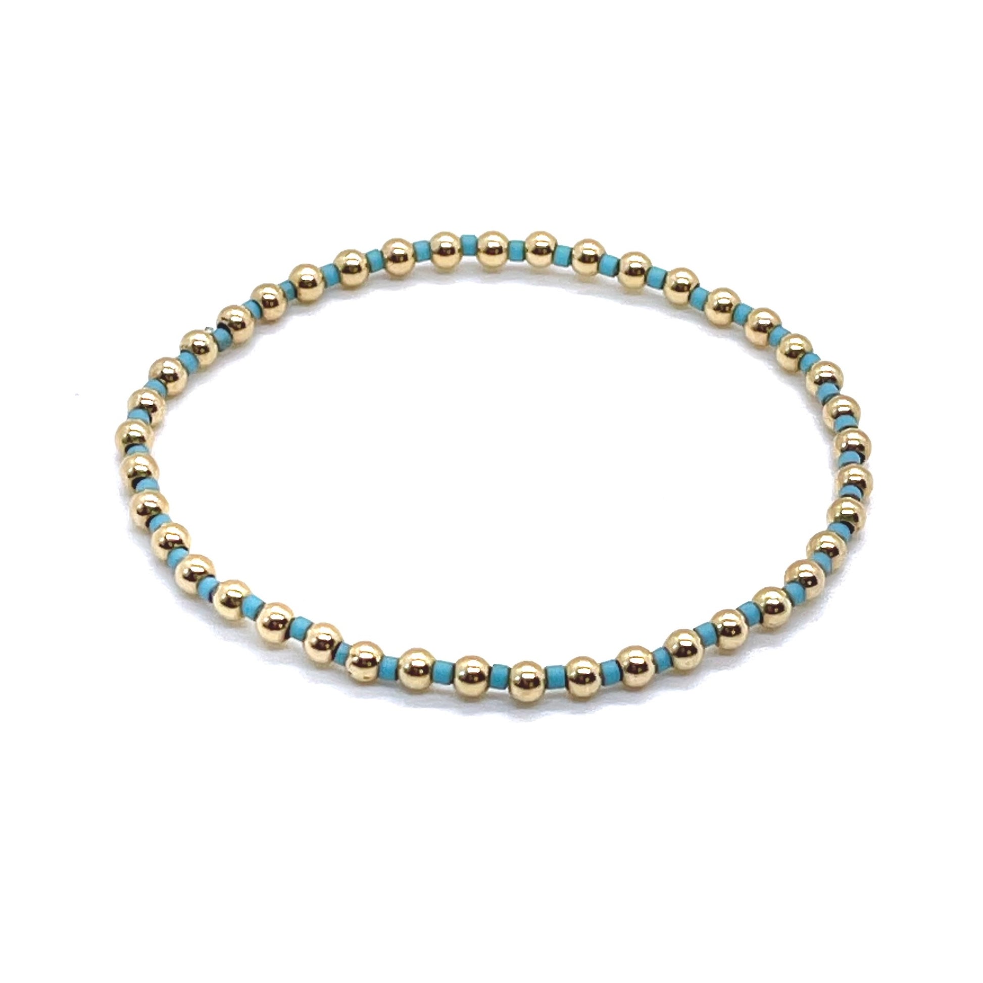 Gold beaded bracelet with alternating turquoise blue seed beads on stretch cord.