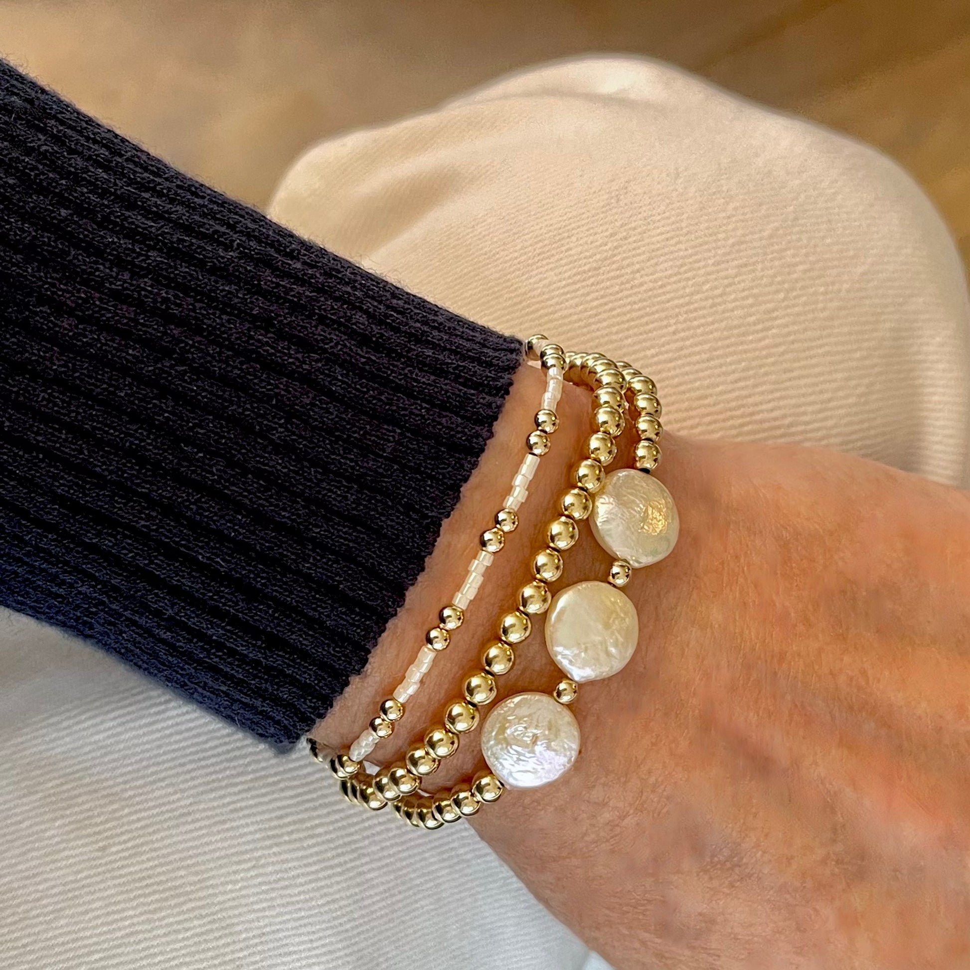 Gold bracelet stack of 3 with freshwater coin pearls and tiny white seed beads on stretchy elastic.