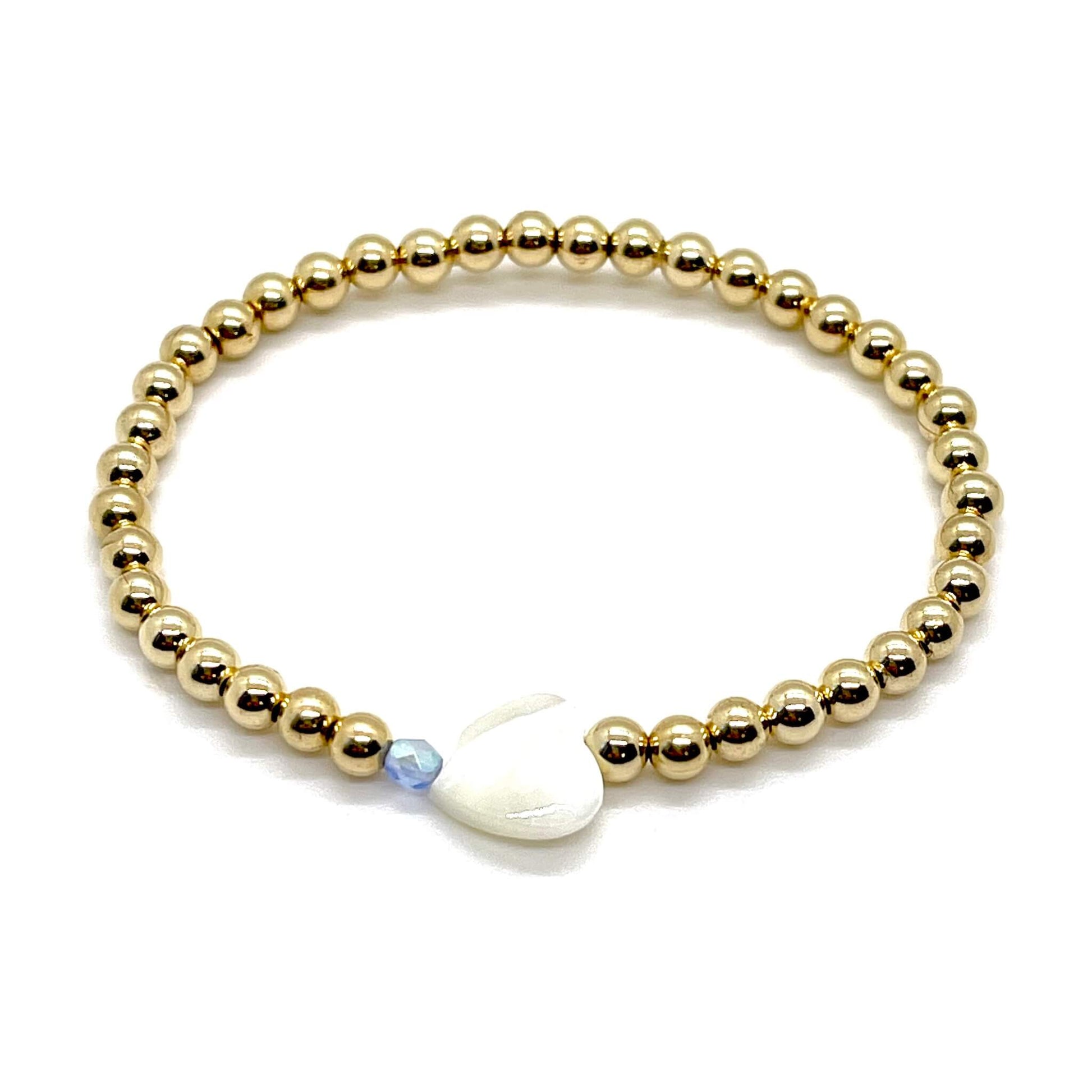 Gold heart bracelet with a mother-of-pearl heart, a small faceted blue crystal, and 4mm 14K gold filled beads.