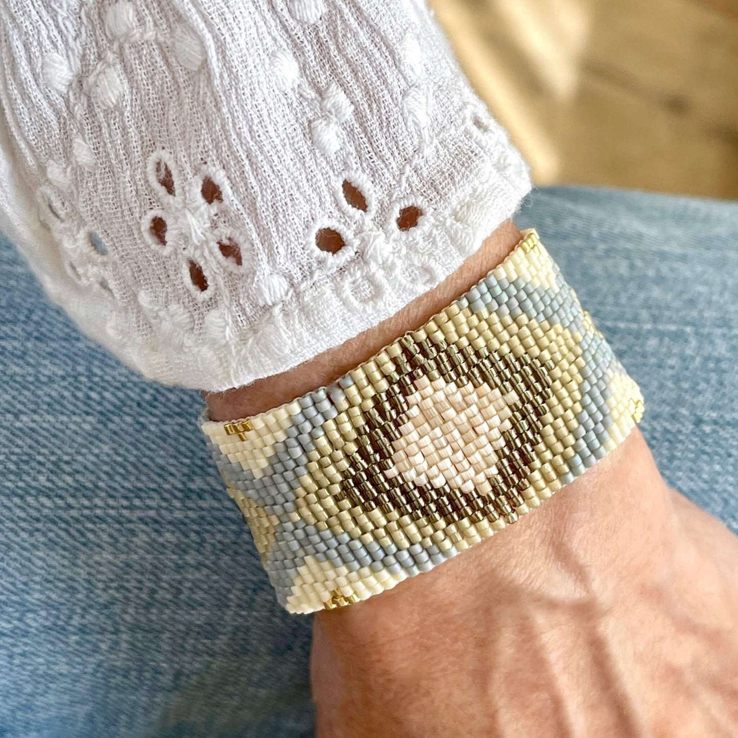 Gold and ivory wide beaded bracelet with seed beads in diamonds and x's patterns.
