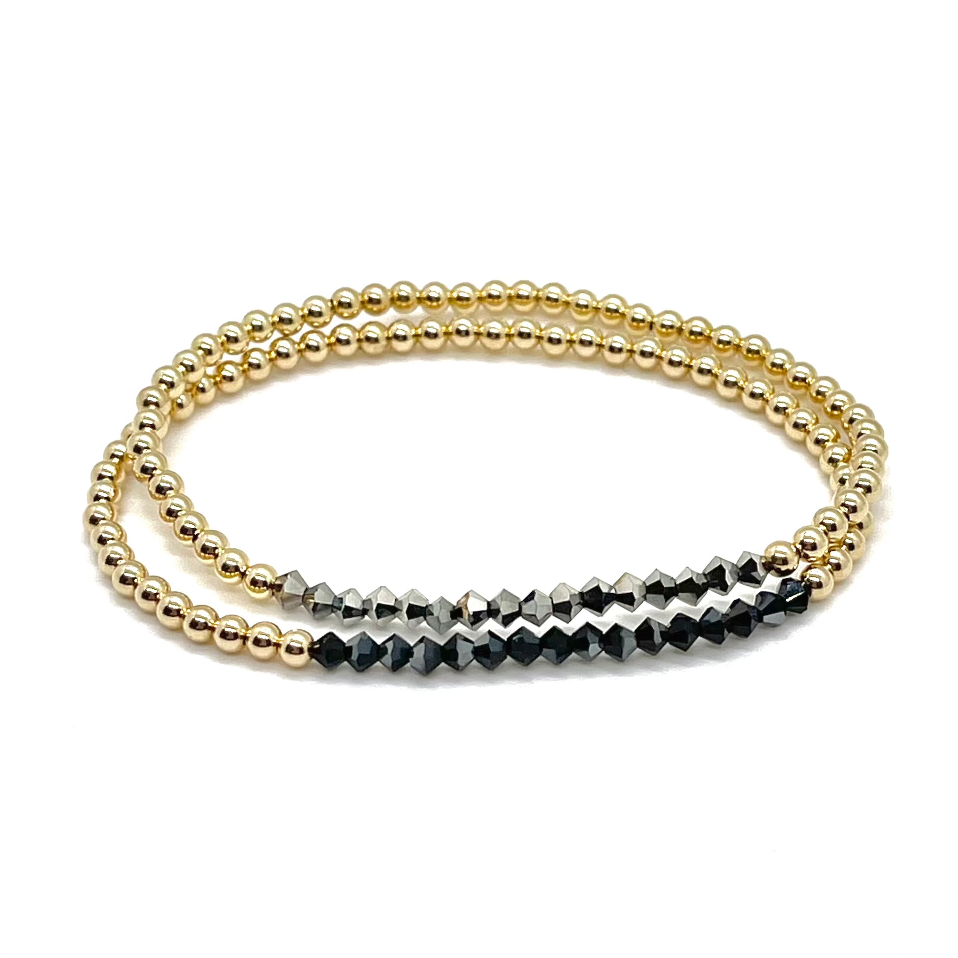 Gold bead bracelets wtih mini crystal diamond-shape beads in black and hematite on stretch cord.