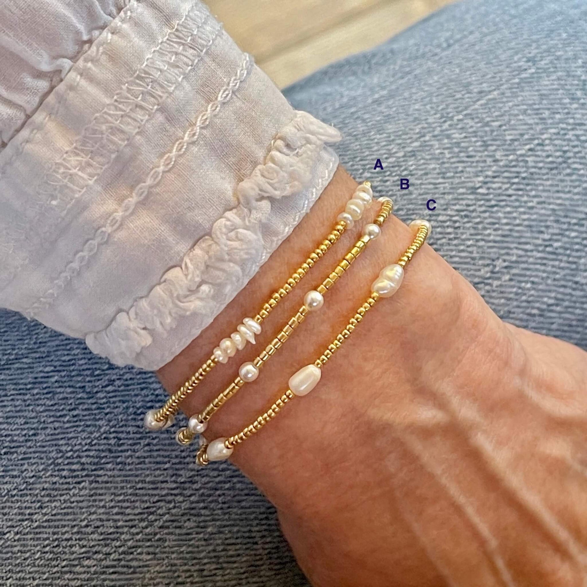 Pearl stacking bracelets with gold-tone seed beads and assorted white freshwater and crystal pearls.