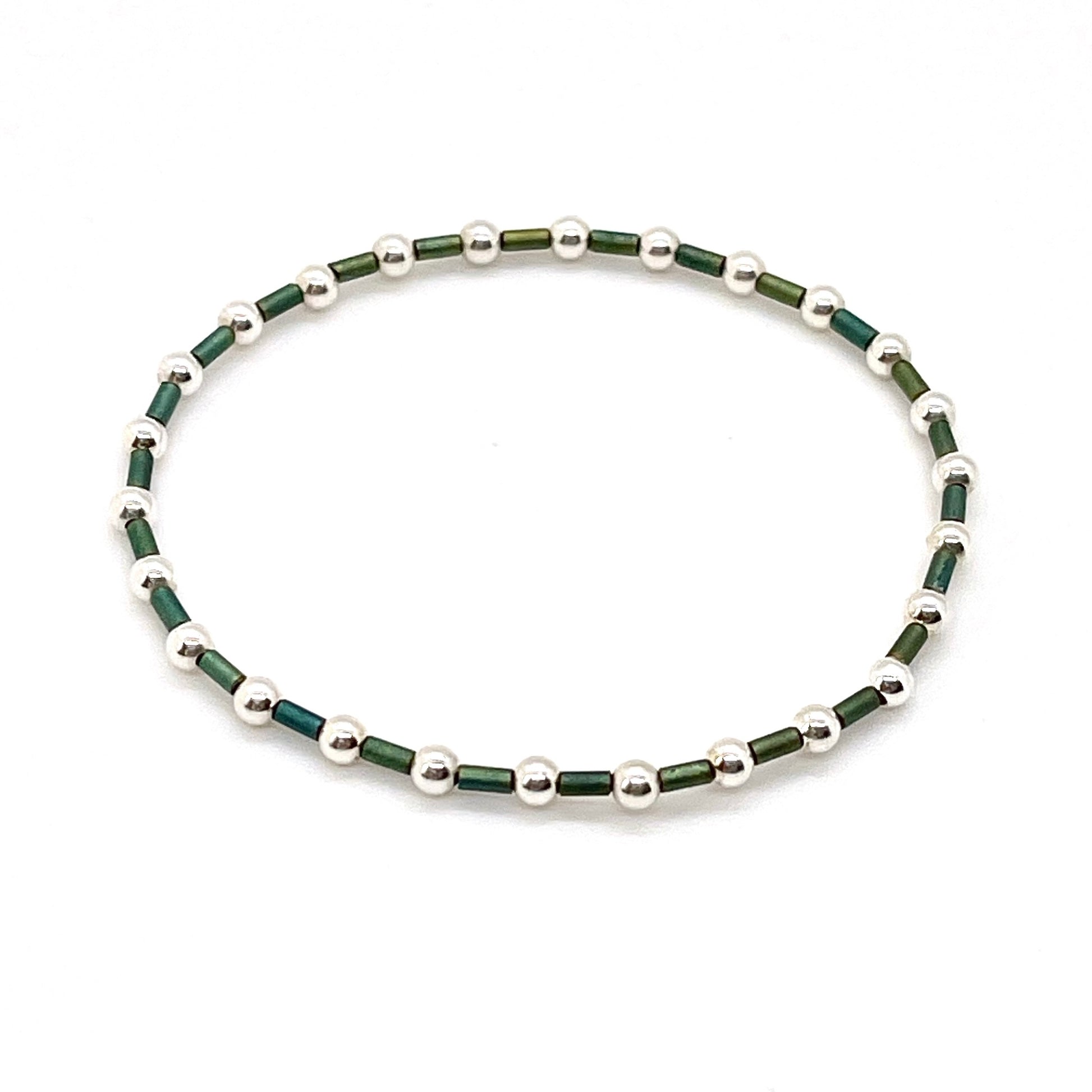 Green seed bead bracelet with 3mm round sterling silver beads on elastic stretch cord.