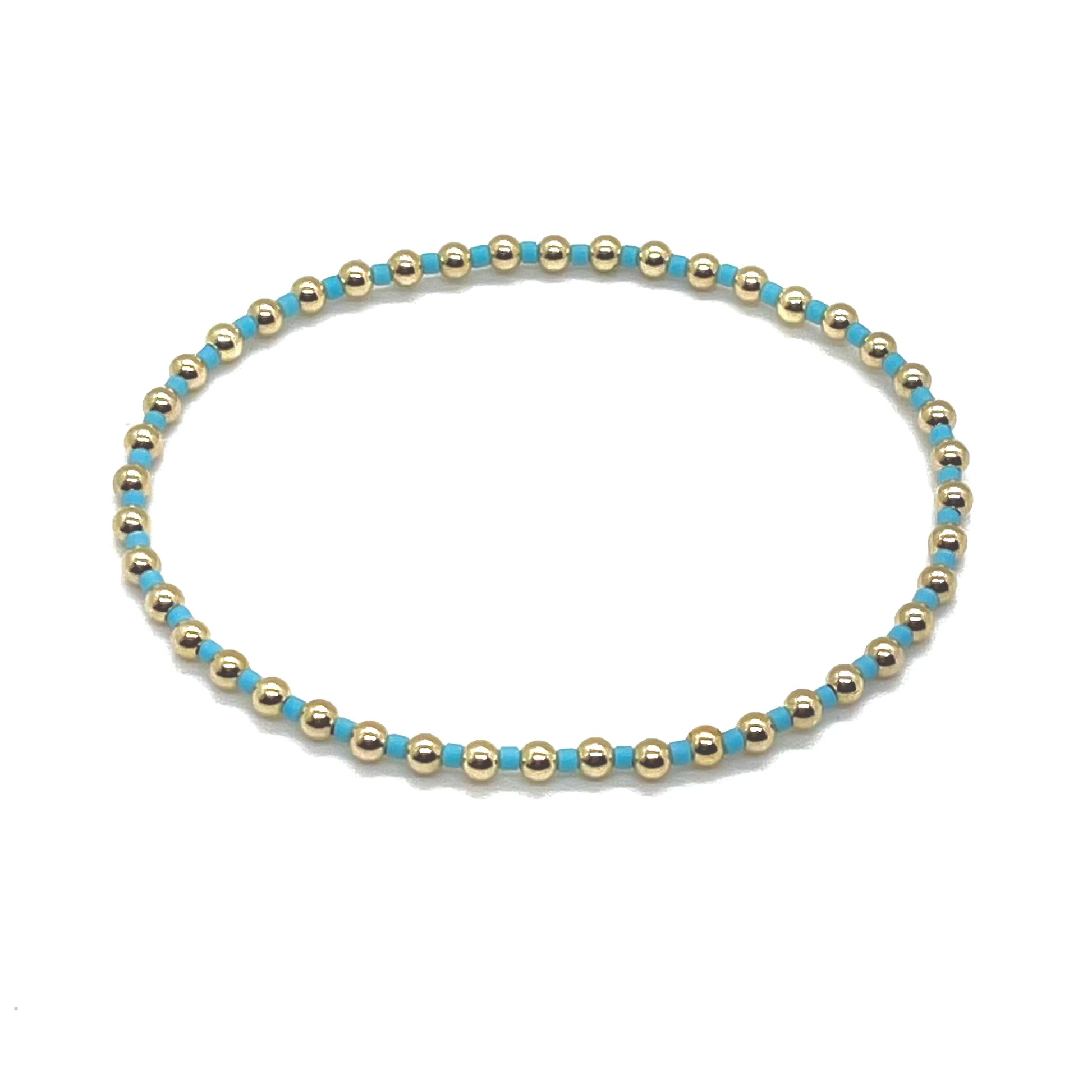 Light blue seed bead and gold ball beaded women's stretch bracelet.