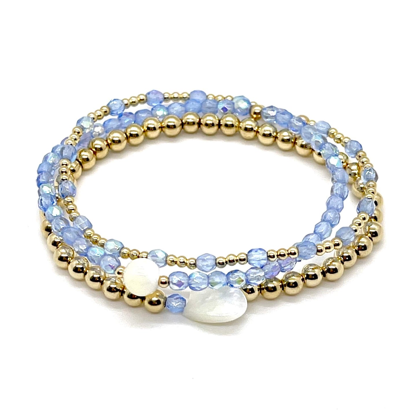 Light blue crystal and gold bracelet stack of 3. Womens handmade stretch bracelets wtih round and heart shaped mother-of-pearl accent beads.