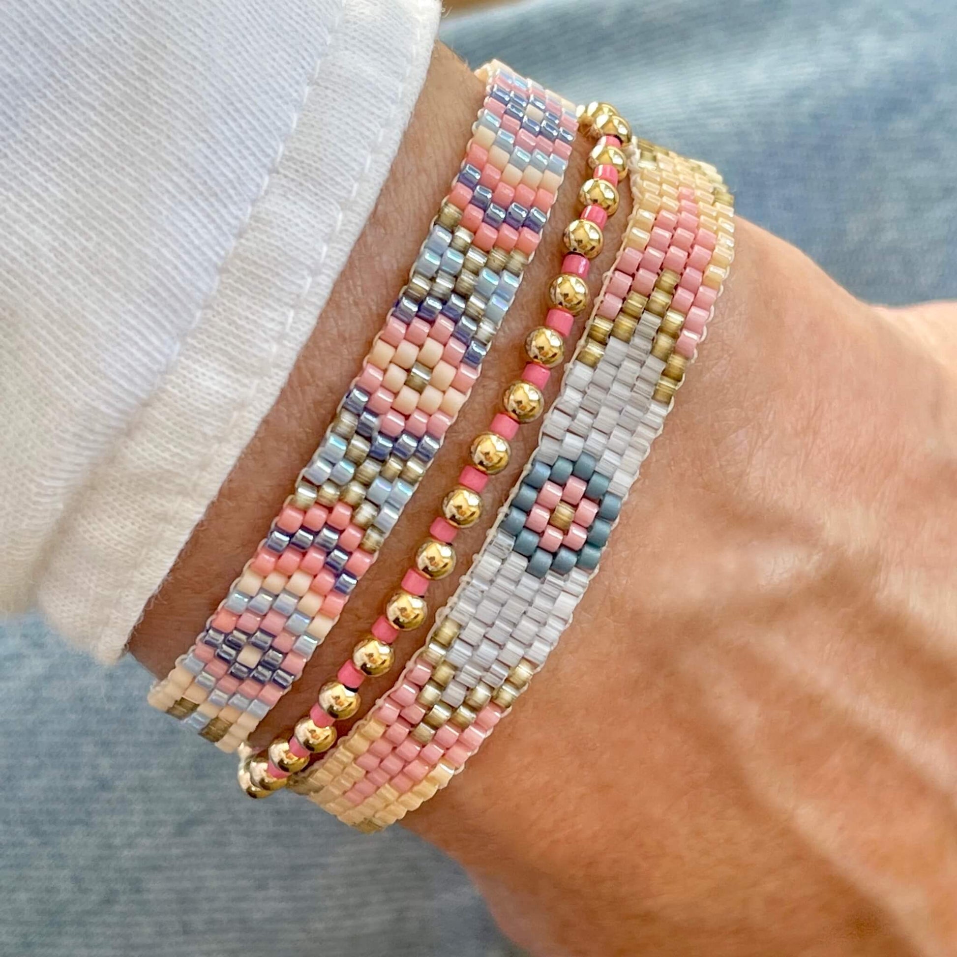 Flat beaded bracelets with pink and blue beads. A boho bracelet stack with pastel colors perfect for spring and summer.