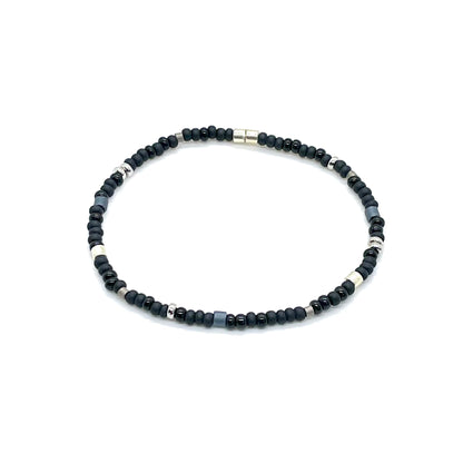 Men's black bead bracelet with matte and glossy black seed beads and silver and slate accent beads on elastic stretch cord.