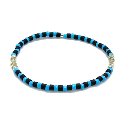 Mens black and light blue bracelet with tube and round shaped glass seed beads and silver-tone accent disks on elastic stretch cord.