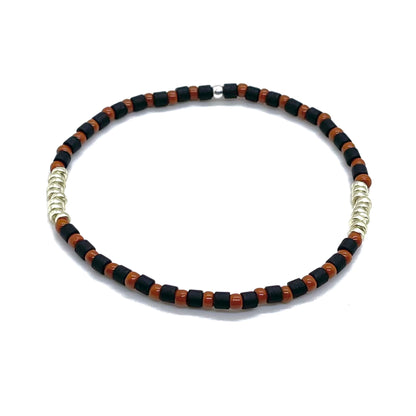 Mens black and brown skinny stretch bracelet with tube and round shaped seed beads and silver tone disks.