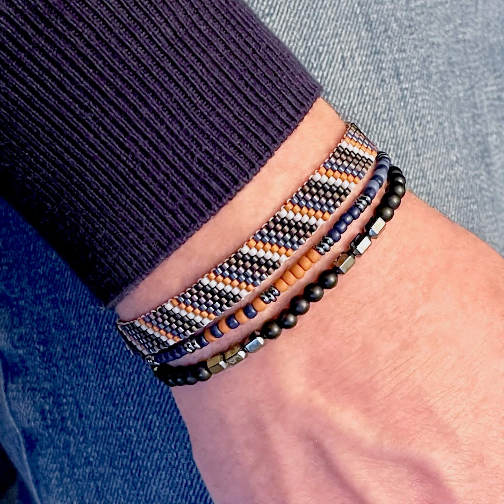 Men’s woven black, blue and rust striped beaded bracelet set with black onyx, hemalyke hematite and seed bead stretch bracelets.