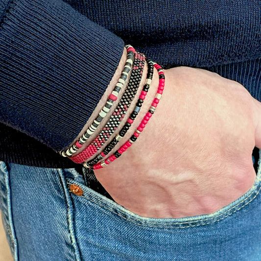 Men’s hand woven red & black ombre beaded bracelet stack with vinyl heishi, and seed bead stretch bracelets.