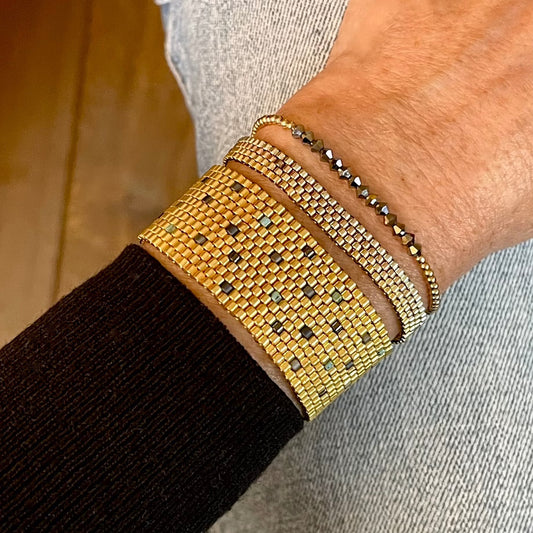 Metal bead bracelet stack with gold metallic woven and stretch bracelets.
