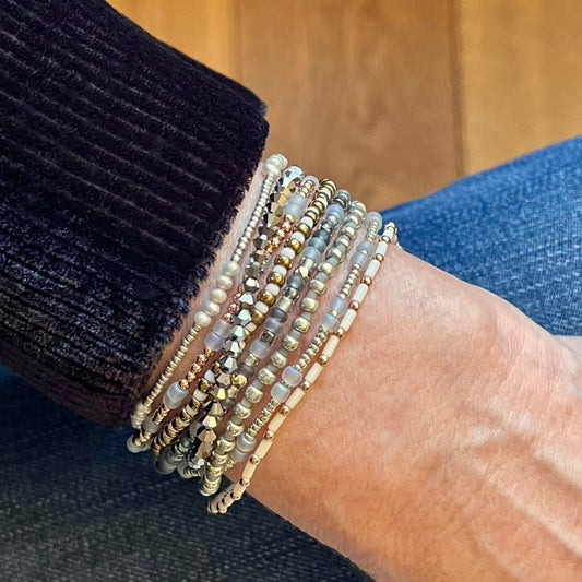 Mixed metal dainty beaded bracelet stack. Gold and silver bracelets with seed beads, freshwater pearls, and crystals.