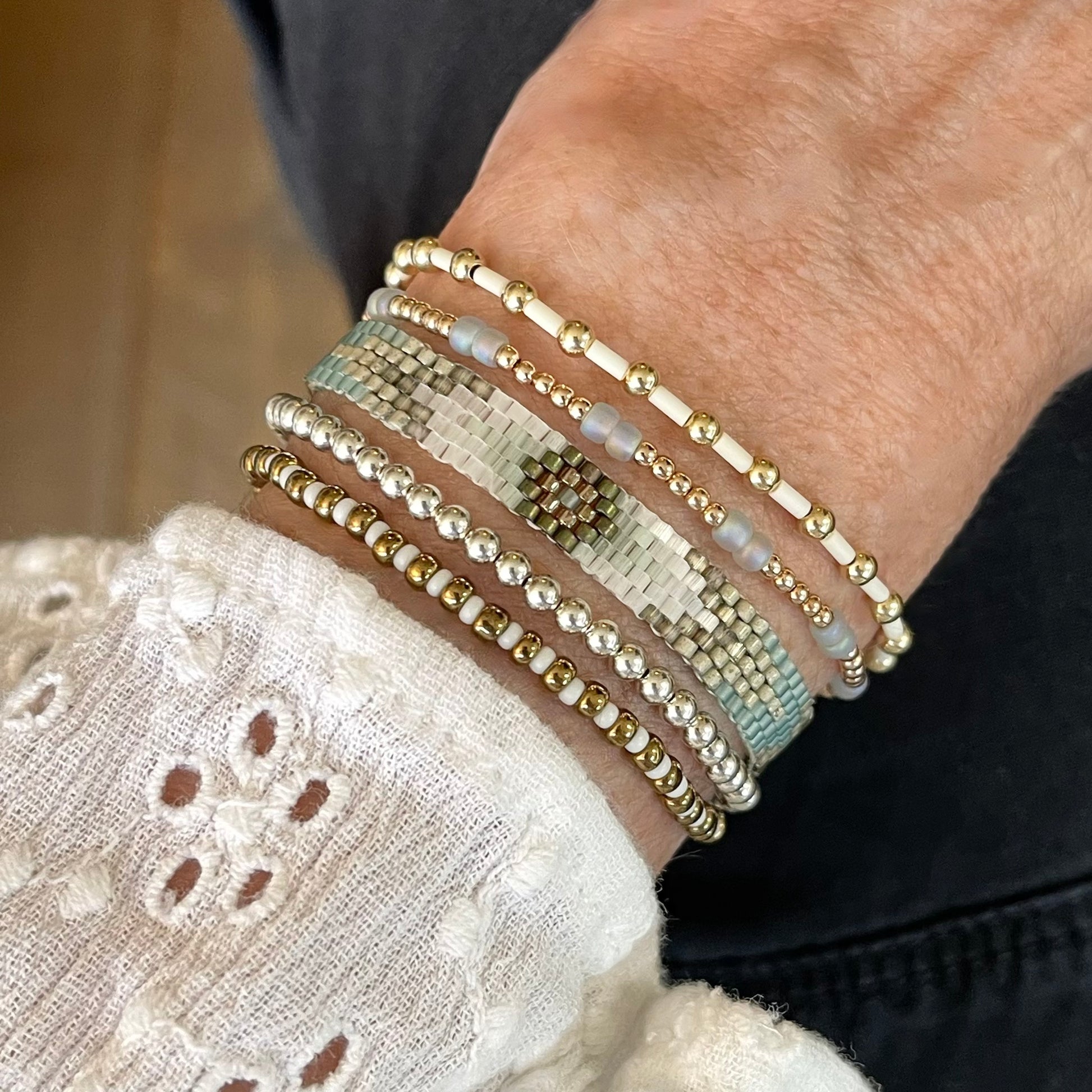 Mixed metal bracelet stack with 14K gold filled, sterling silver, bronze & ivory beads with a green woven cuff bead peyote bracelet.