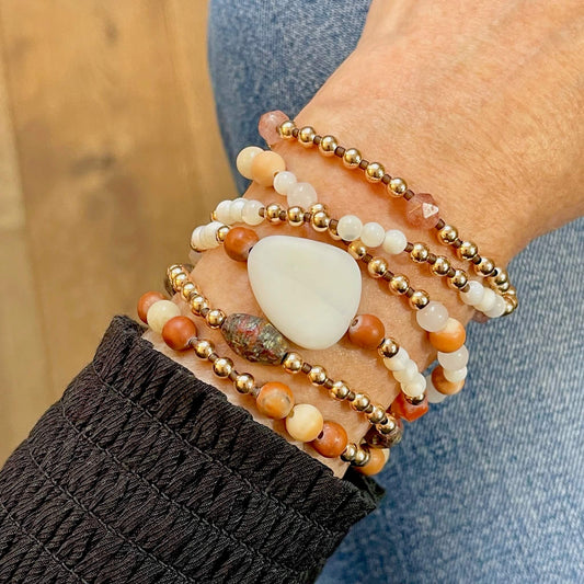 Multi strand wrap bracelet with rose gold filled and white mother of pearl beads, and rust gemstones and crystals on a stretch cord.