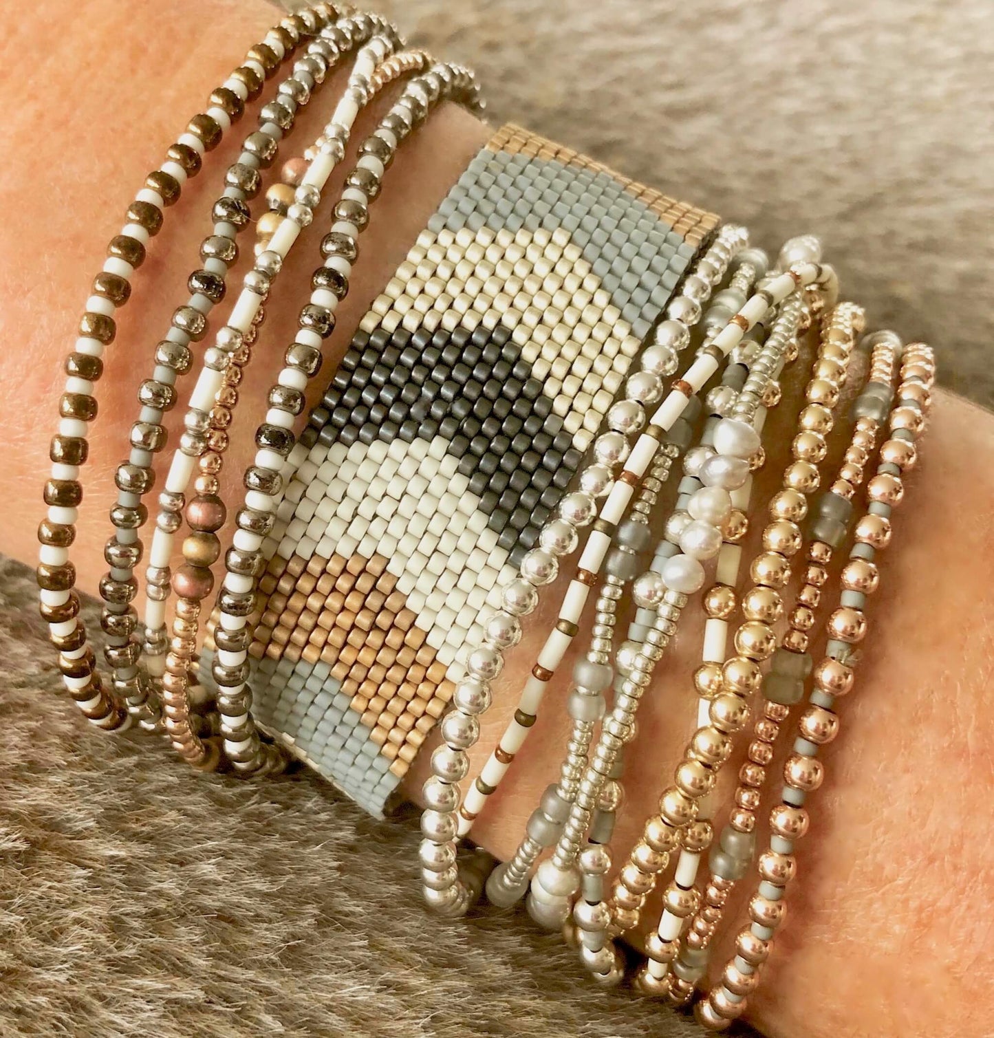 Neutral color gold and silver beaded stretch and woven bracelet stack with handmade chevron cuff band, seed beads, and mixed metals.