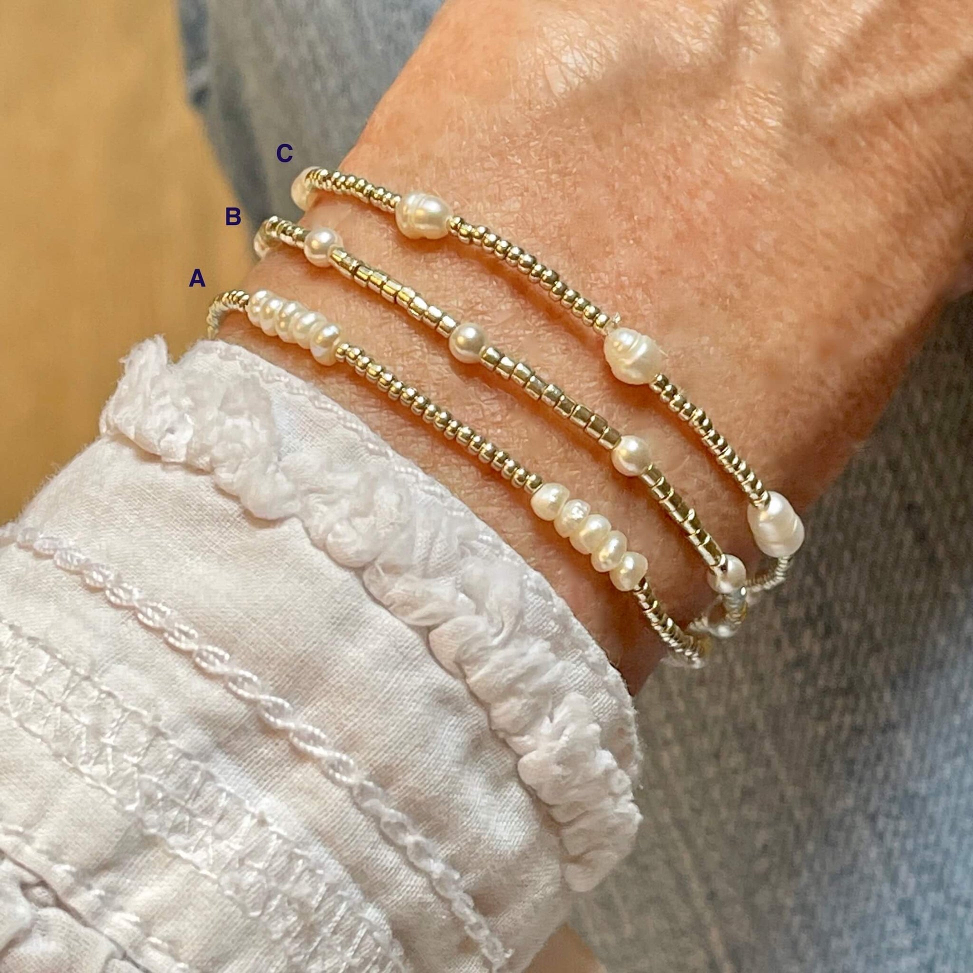 Stackable pearl bracelets with silver-tone seed beads and assorted white freshwater and crystal pearls.