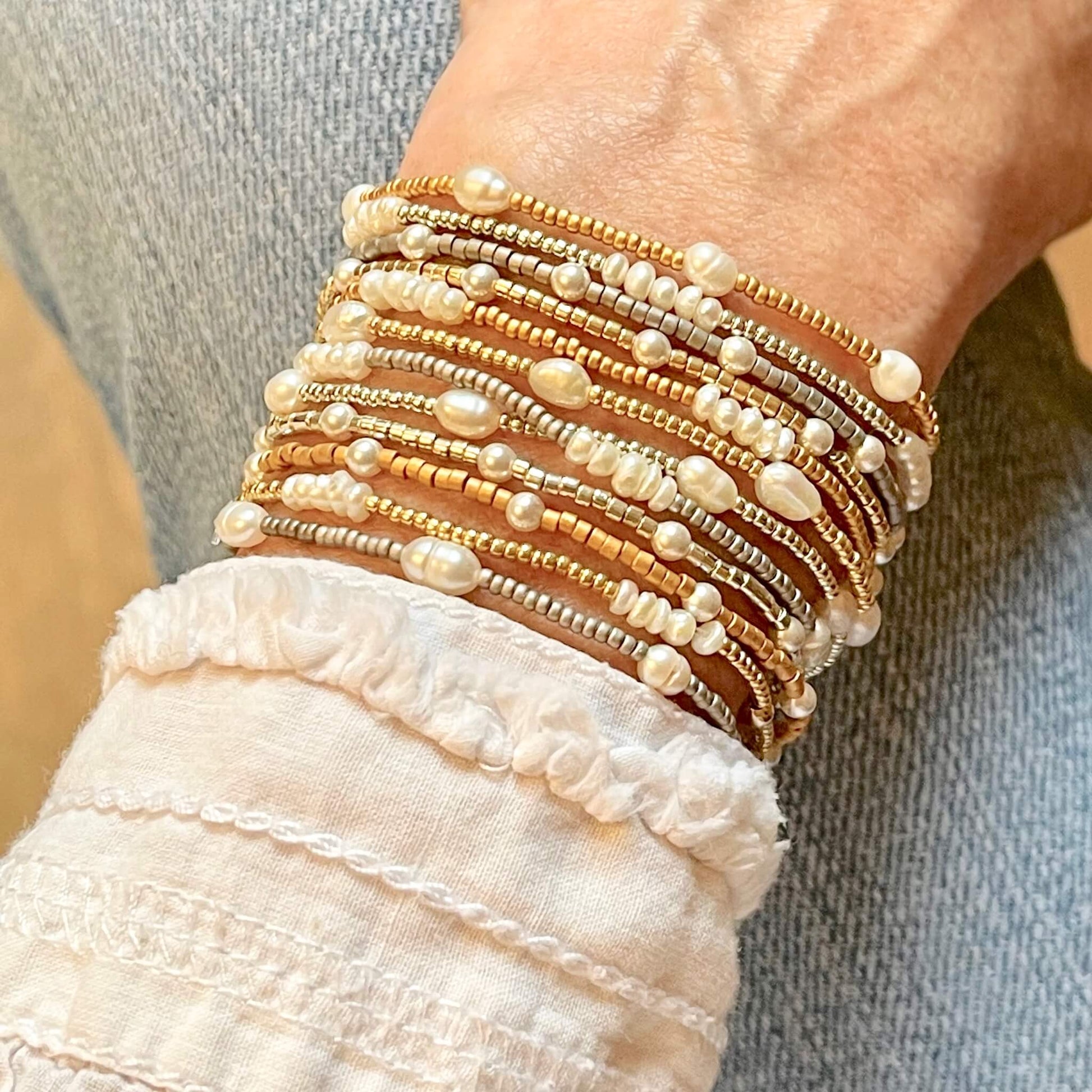 Hand beaded delicate stackable stretch bracelets with pearls and gold-tone or silver-tone seed beads.