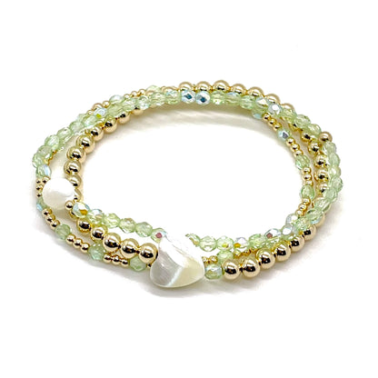 Peridot crystal and gold bracelet stack of 3. Womens handmade stretch bracelets wtih round and heart shaped mother-of-pearl accent beads.