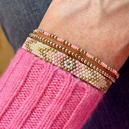 Pink beaded bracelets with gold beads. Bracelet set with flat beaded bracelet and gold ball bracelets.