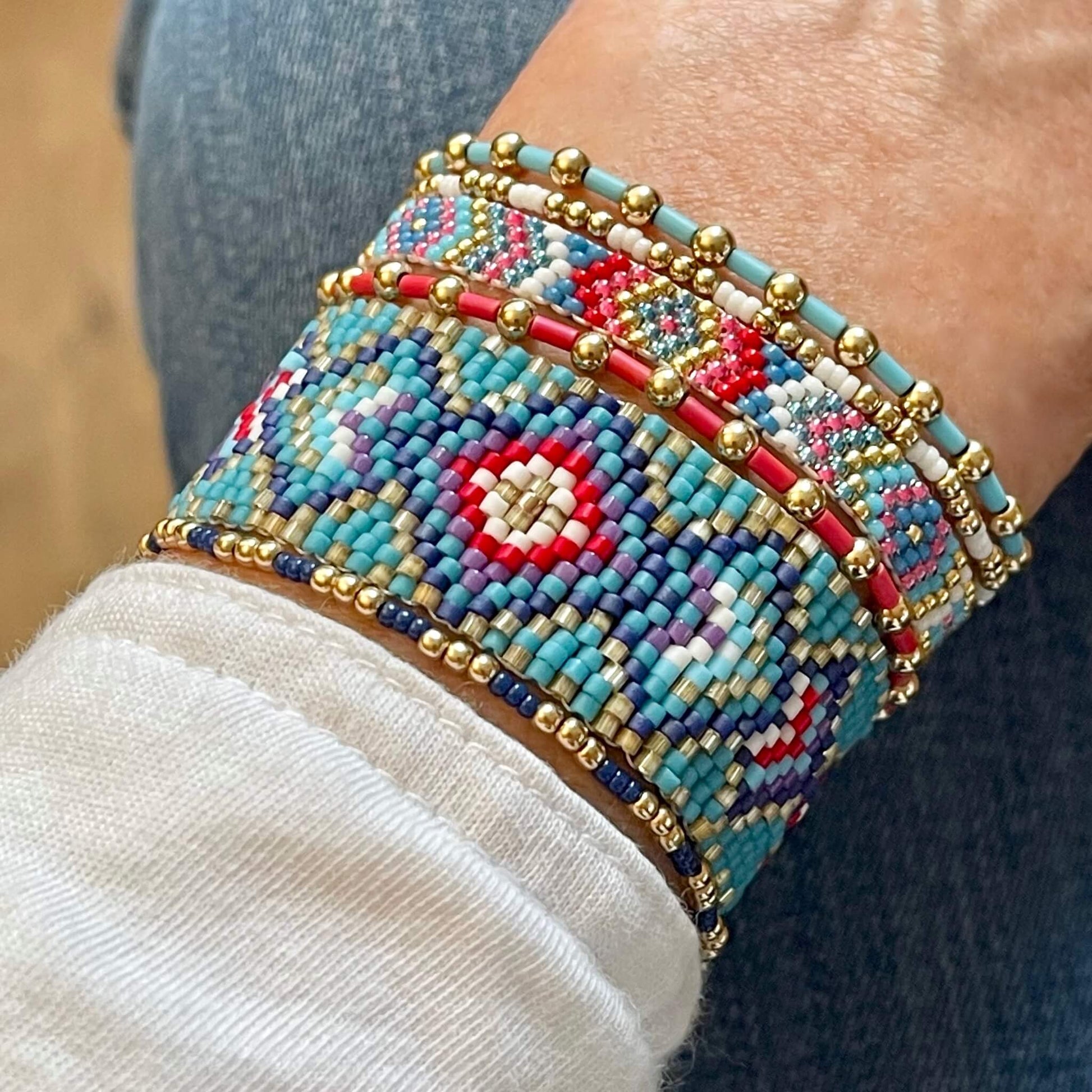 Santa Fe inspired stretchy bracelets and flat beaded bracelets with turquoise, red, white, purple, and gold seed beads.